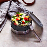An open Black+Blum Leakproof Microwave Safe Glass Lunch Bowl filled with pasta, basil and tomatoes.  The lid and a stainless steel fork are resting besides it. This lunch box is part of a wide range of reusable stainless steel lunch wares here at Babipur. 