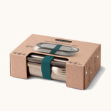 Black+Blum Large Leak Proof Stainless Steel Lunch Box with ocean coloured strap shown in it's cardboard packaging box. This lunchbox is part of a wide range of stainless steel lunch box options available here at Babipur. 