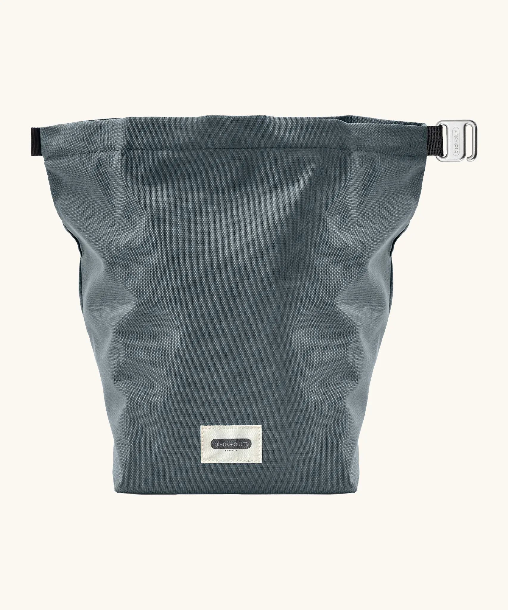 An open A slate blue Black+Blum water repellent roll top lunch bag with contents inside 