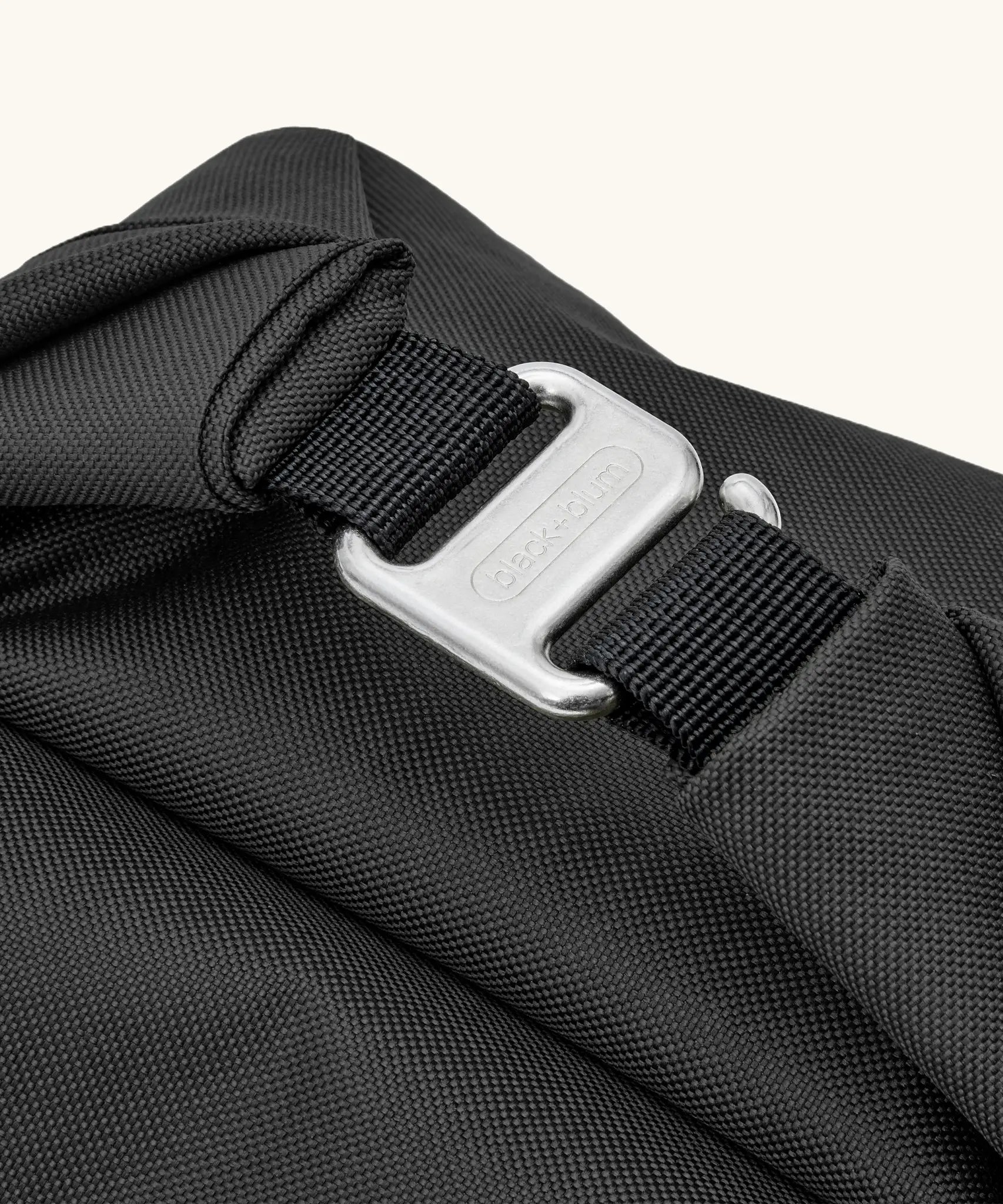 Close up the metal hook buckle fastener for the Black+Blum roll top lunch bag in black 