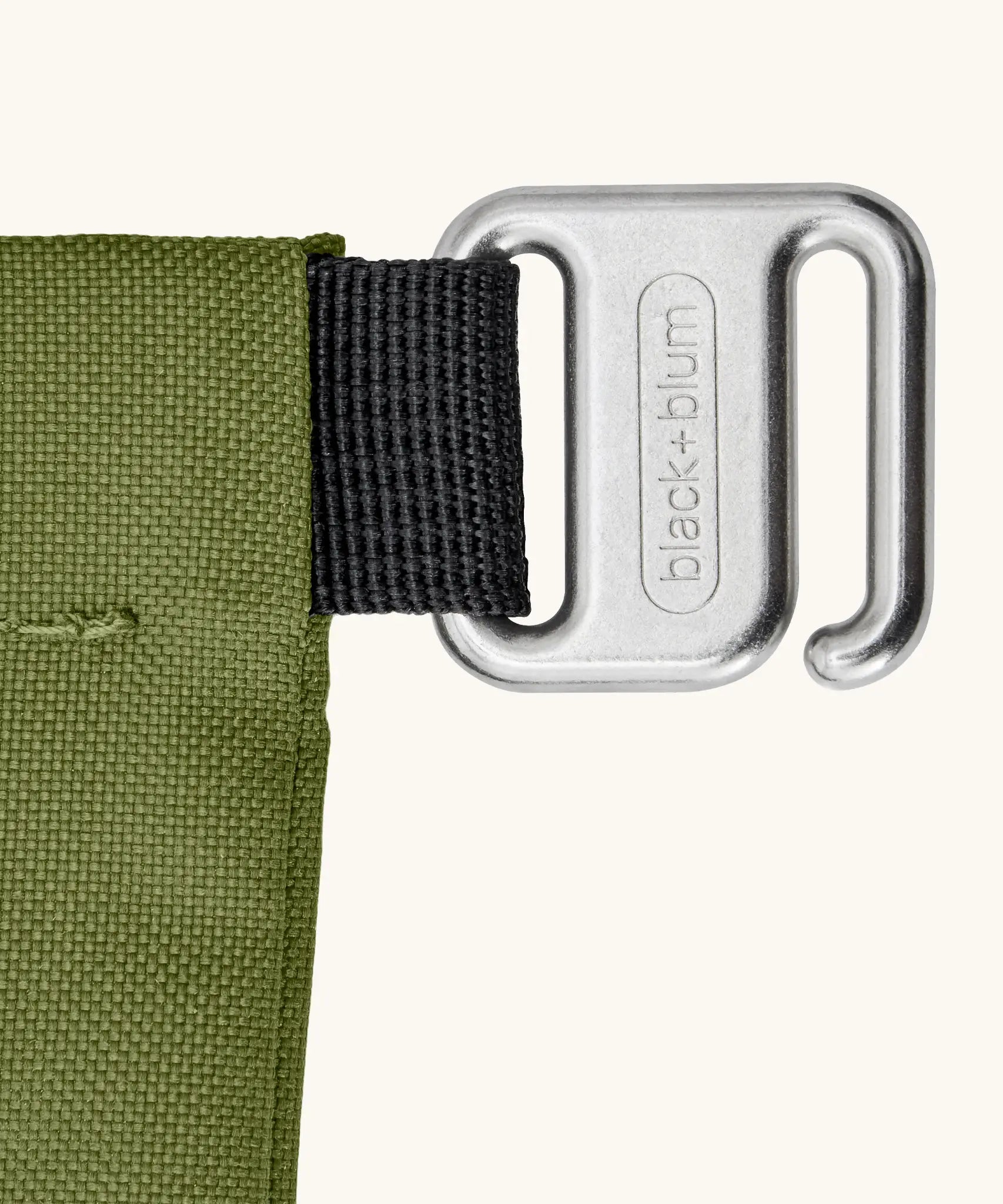Close up of the metal hook buckle fastener on the moss green Black+Blum water repellent roll top lunch bag