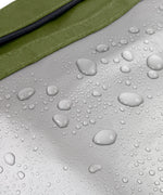 The water repellent lining on the moss green Black+Blum lunch bag showing trickling water