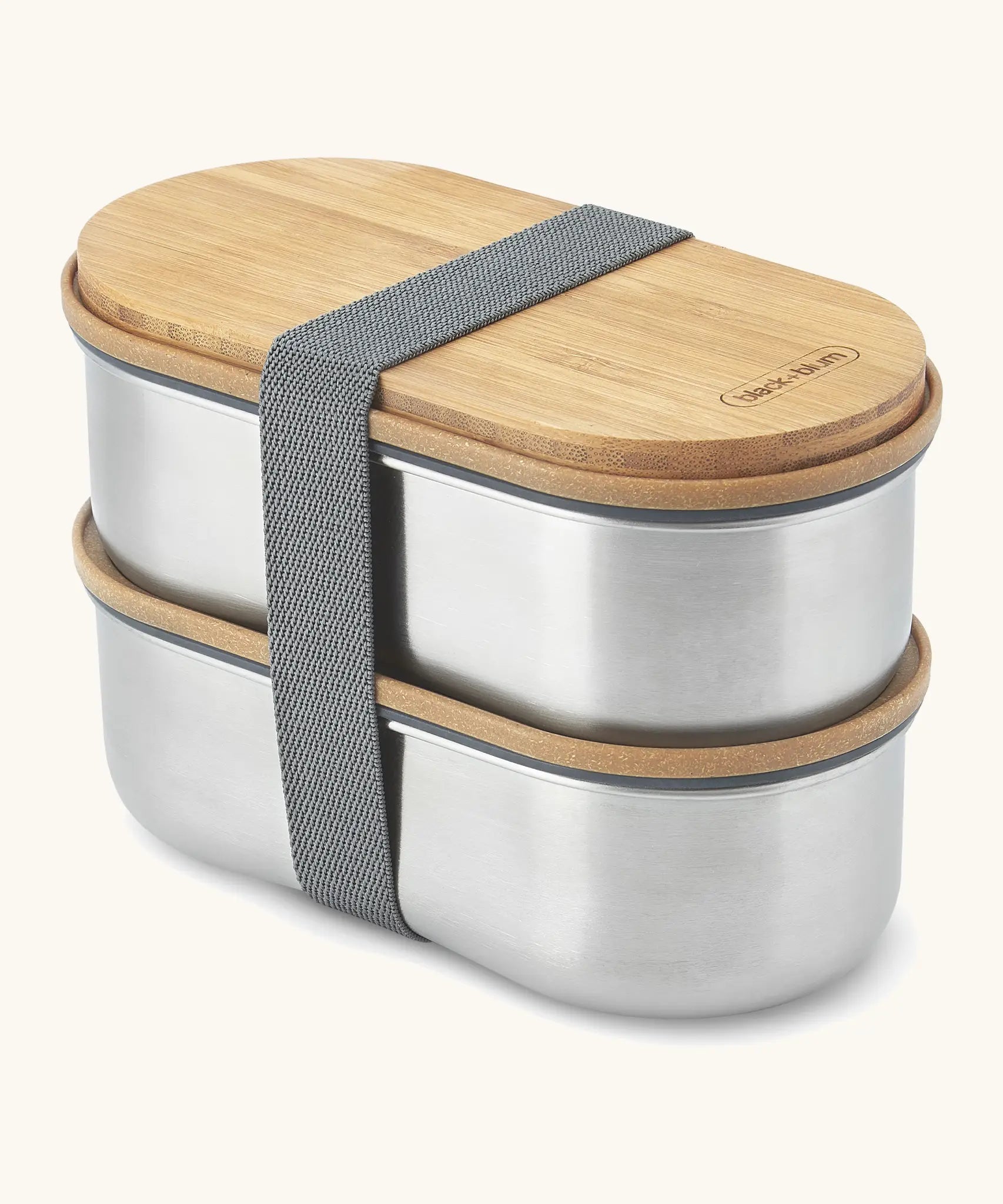 Angled Black+Blum two 500ml stainless steel leakproof boxes with a bamboo lid/chopping board and nylon strap