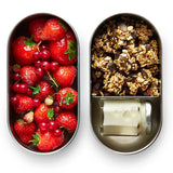 Two open Black+Blum 500ml stainless steel leakproof lunchboxes showing  small jar of milk in one with oats and fruits