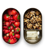 Two open Black+Blum 500ml stainless steel leakproof lunchboxes showing  small jar of milk in one with oats and fruits