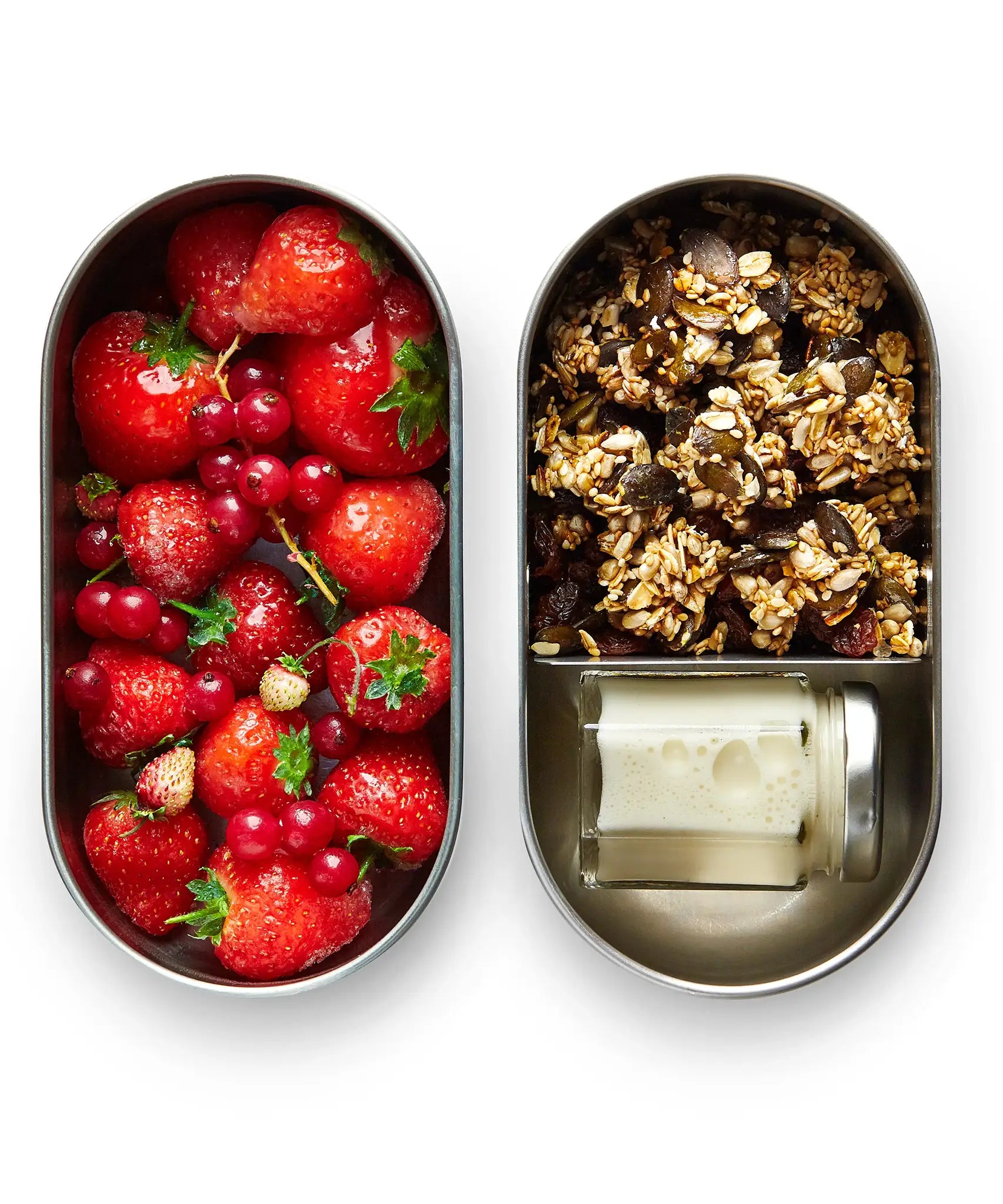 Two open Black+Blum 500ml stainless steel leakproof lunchboxes showing  small jar of milk in one with oats and fruits