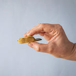 A hand holding the Bumbu wooden beaver figure 