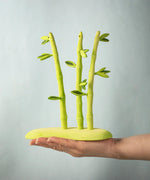 A hand holding the Bumbu wooden bamboo set for scale and height