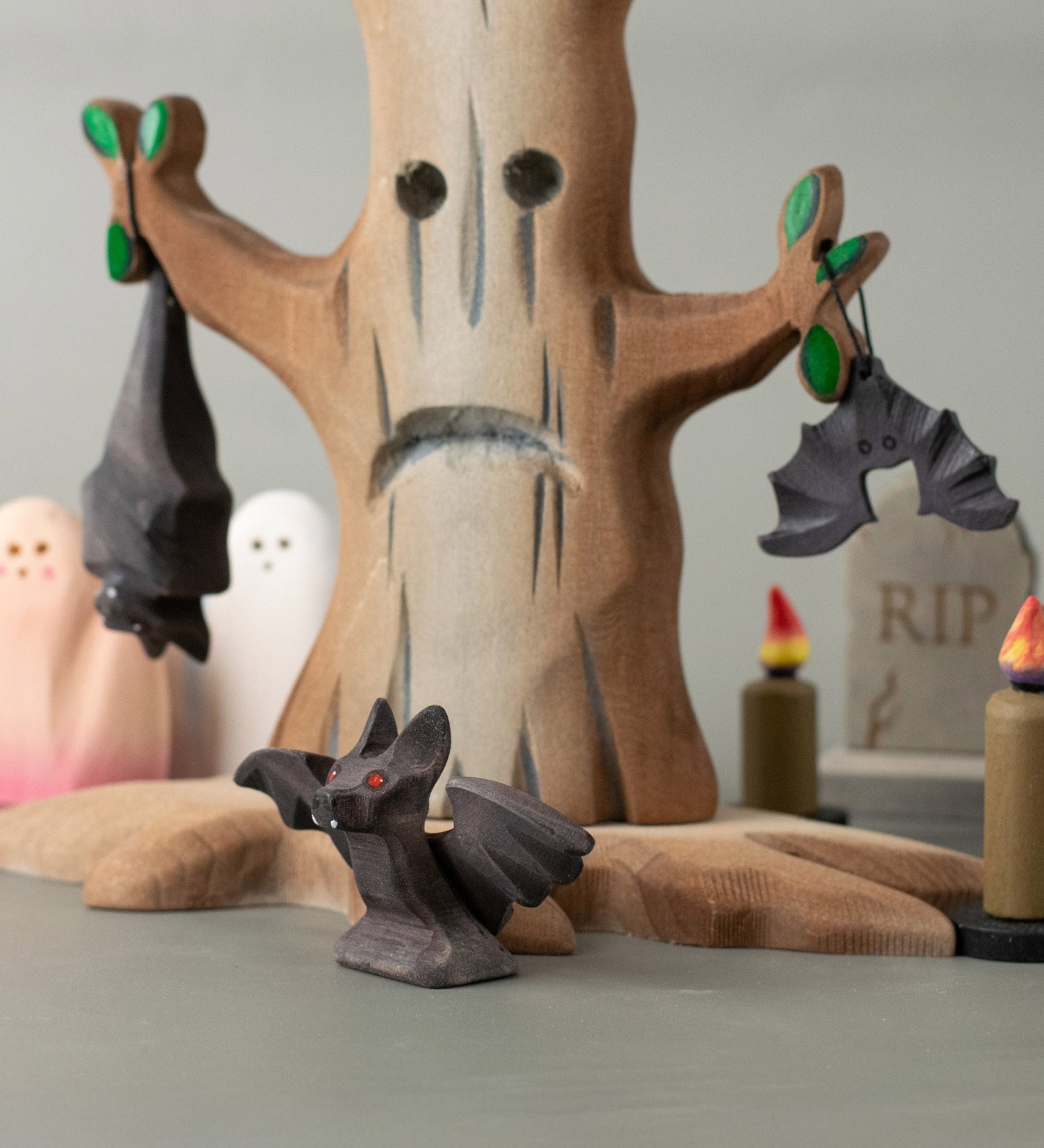 All 3 Bumbu bat figures in a spooky playscene including a spooky tree, candles ghosts and a tombstone all available at Babipur.