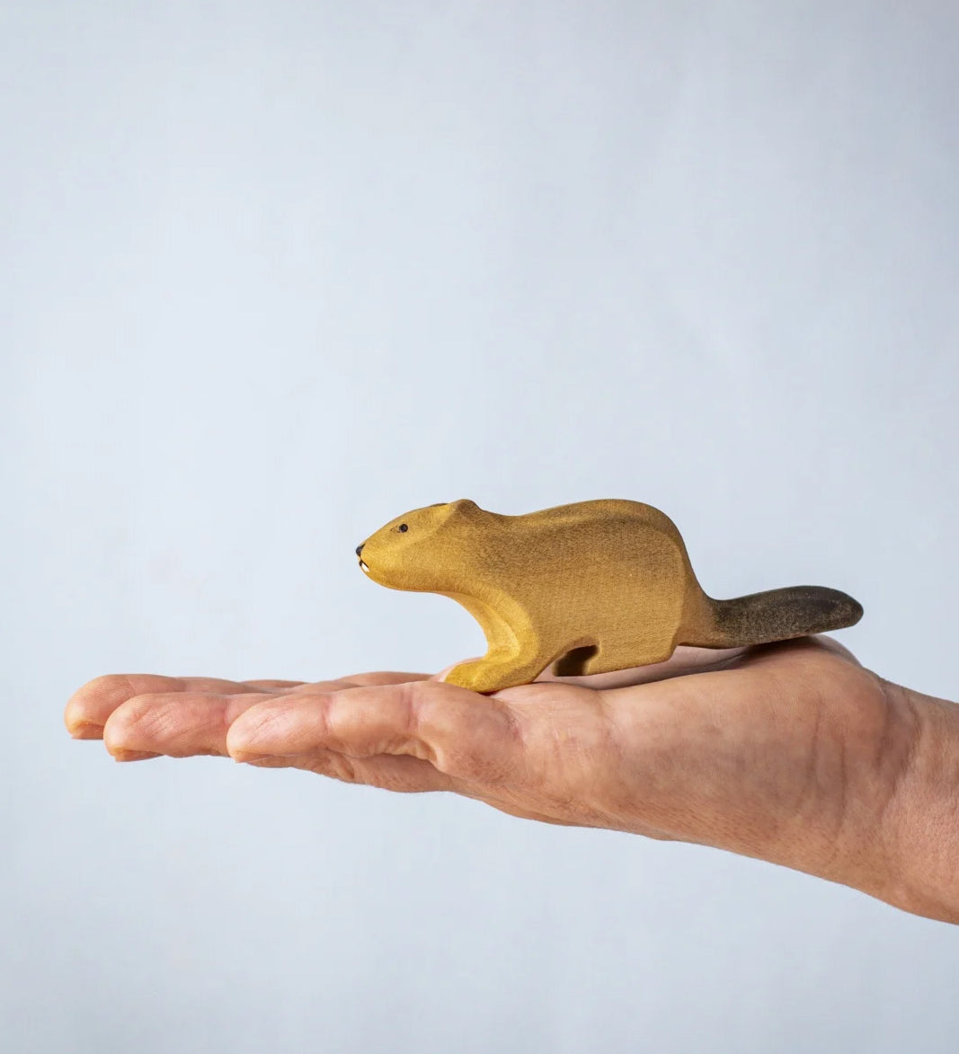 A hand holding the Bumbu wooden beaver figure