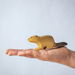 A hand holding the Bumbu wooden beaver figure