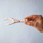 A hand holding the Bumbu wooden birch branch