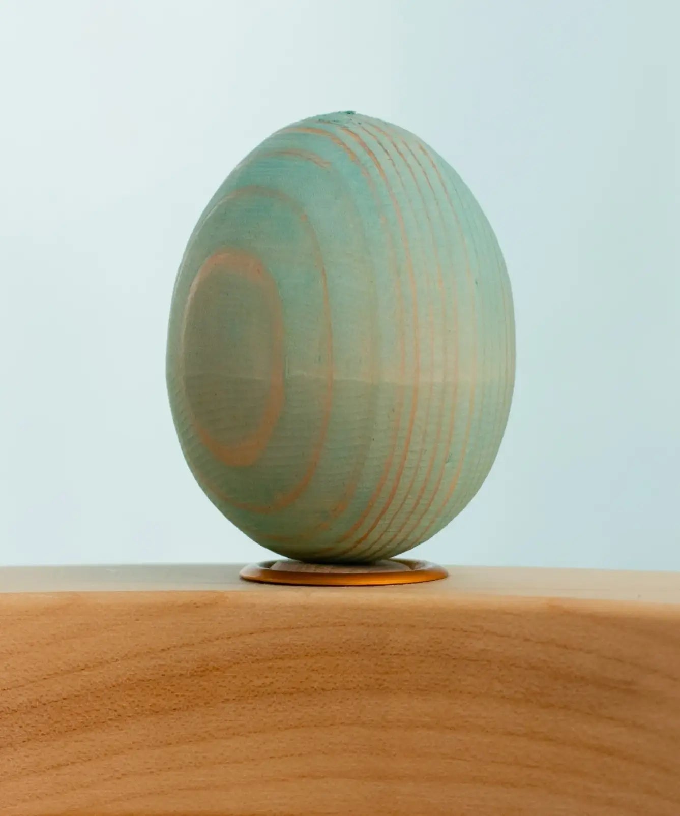 Bumbu wooden hand painted festive blue egg decorative figure standing in a celebration ring with a blue background