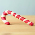 A red and white wooden Bumbu candy cane