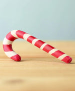 A red and white wooden Bumbu candy cane