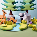 stag and fawn toys on a wooden worktop in front of a blue background