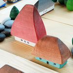 Close up of the Bumbu eco-friendly wooden Crisana houses on a wooden table surrounded by grapat mandala trees