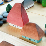 Close up of the Bumbu eco-friendly wooden Crisana houses on a wooden table surrounded by grapat mandala trees