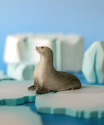 Bumbu curious harp seal wooden toy figure placed on an ice piece in a small world play scene.
