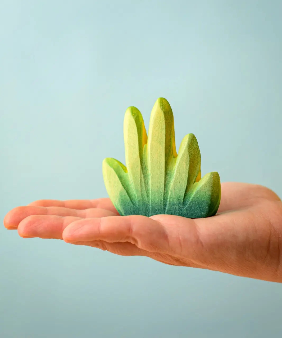 Bumbu Toys dessert bush for small world play in an adult's hand.