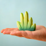 Bumbu Toys dessert bush for small world play in an adult's hand.