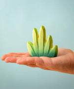 Bumbu Toys dessert bush for small world play in an adult's hand.
