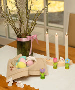 Easter display showing blue, pink and yellow Bumbu eggs with white rabbits and spring flower figures