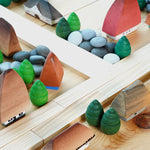 Bumbu handmade miniature wooden house toys laid out in a small town next to some Kapla planks and Grapat mandala pieces