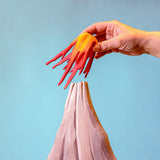 Bumbu Wooden Volcano Set. An adult hand is shown removing the lava section.