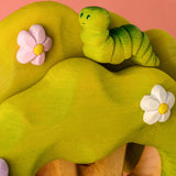 Bumbu caterpillar resting on top of the Bumbu toys wooden fairy treehouse 