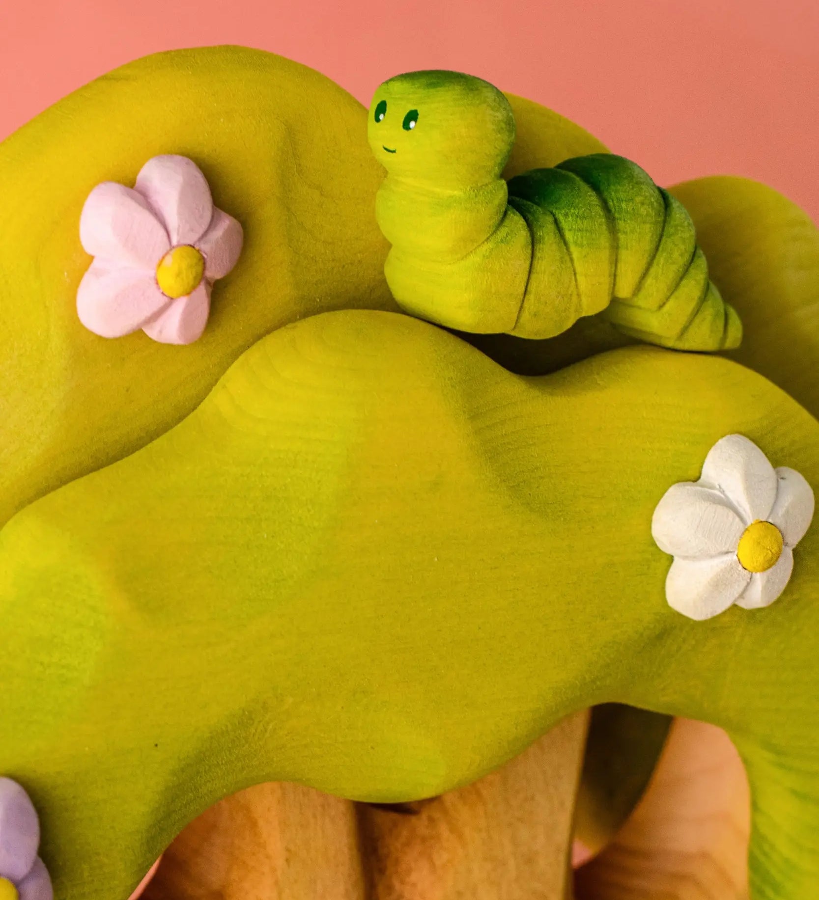 Bumbu caterpillar resting on top of the Bumbu toys wooden fairy treehouse 