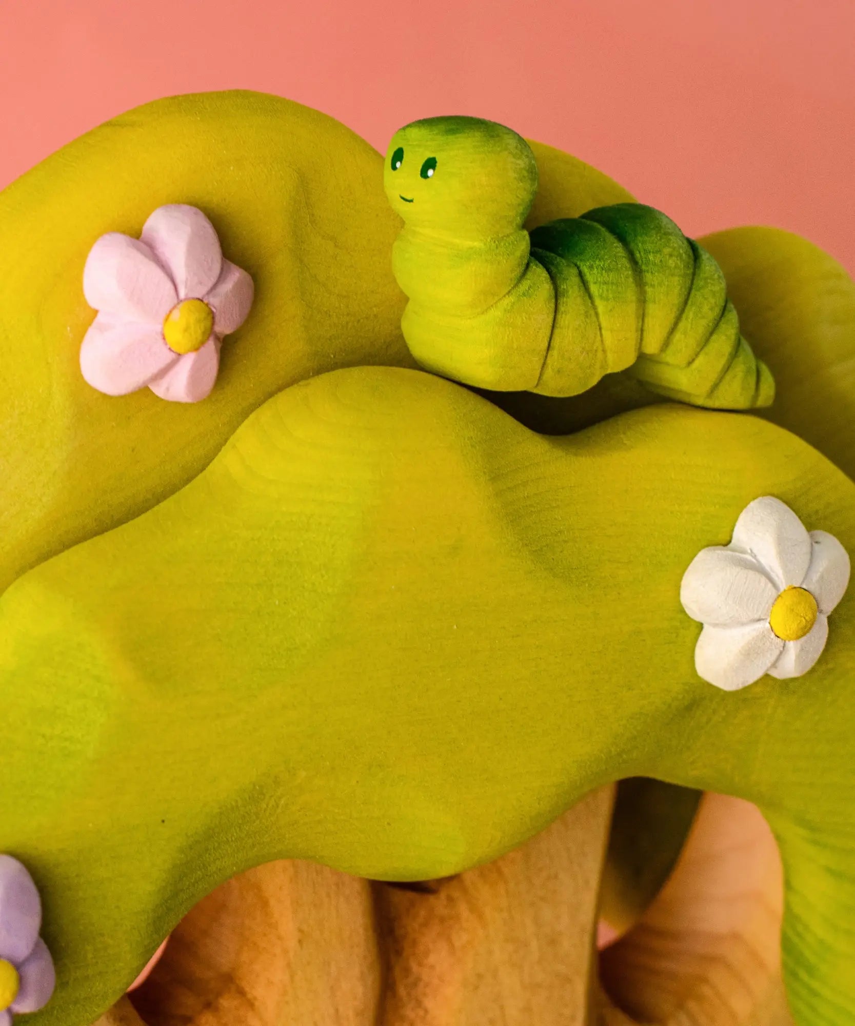 Bumbu caterpillar resting on top of the Bumbu toys wooden fairy treehouse 