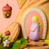 Bumbu pink fairy standing inside the doorway on the Bumbu fairy treehouse next to the hanging lantern and caterpillar figure 
