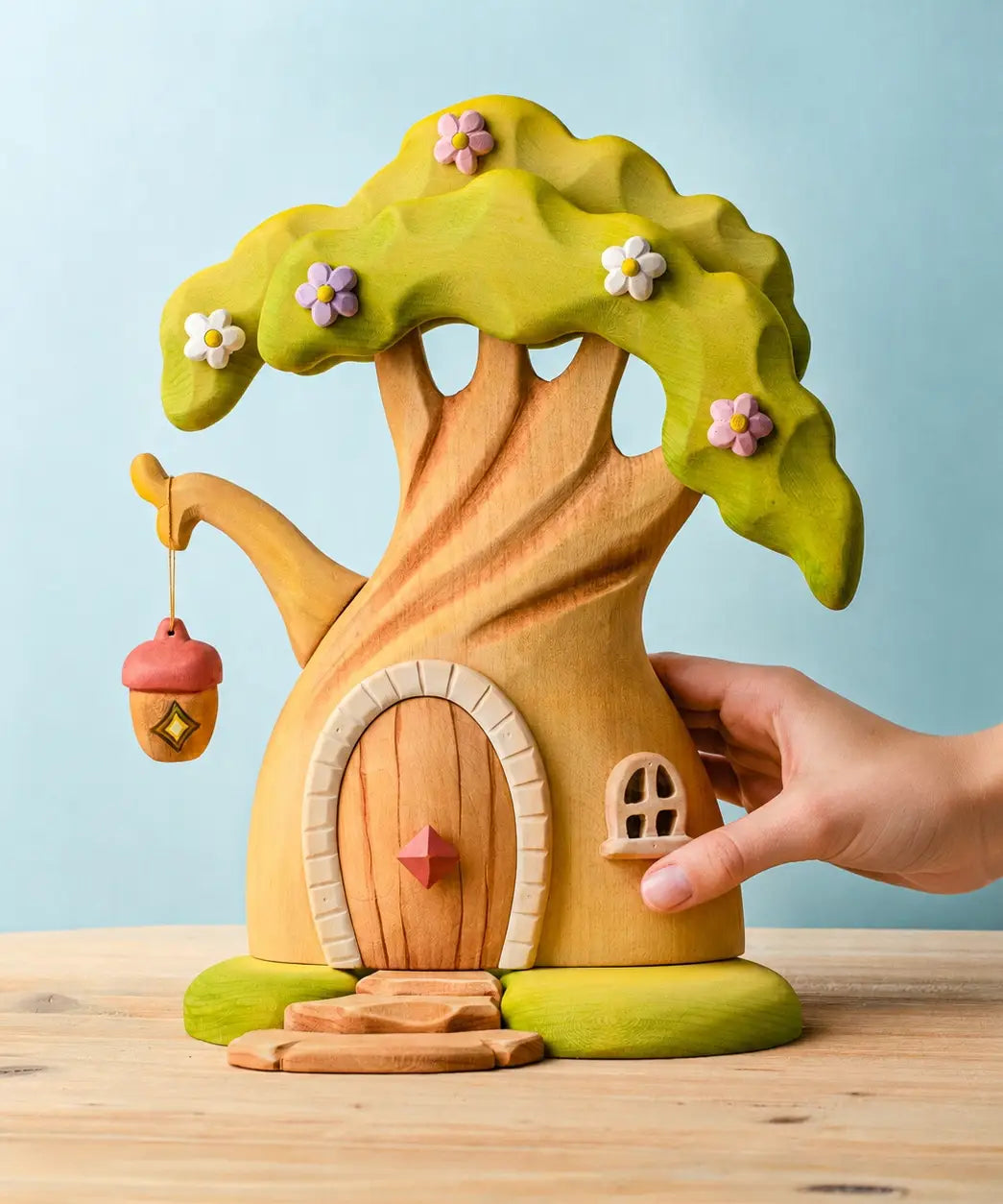 Adult hand holding the Bumbu toys handcrafted fairy treehouse showing scale
