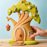 Adult hand holding the Bumbu toys handcrafted fairy treehouse showing scale