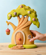 Adult hand holding the Bumbu toys handcrafted fairy treehouse showing scale
