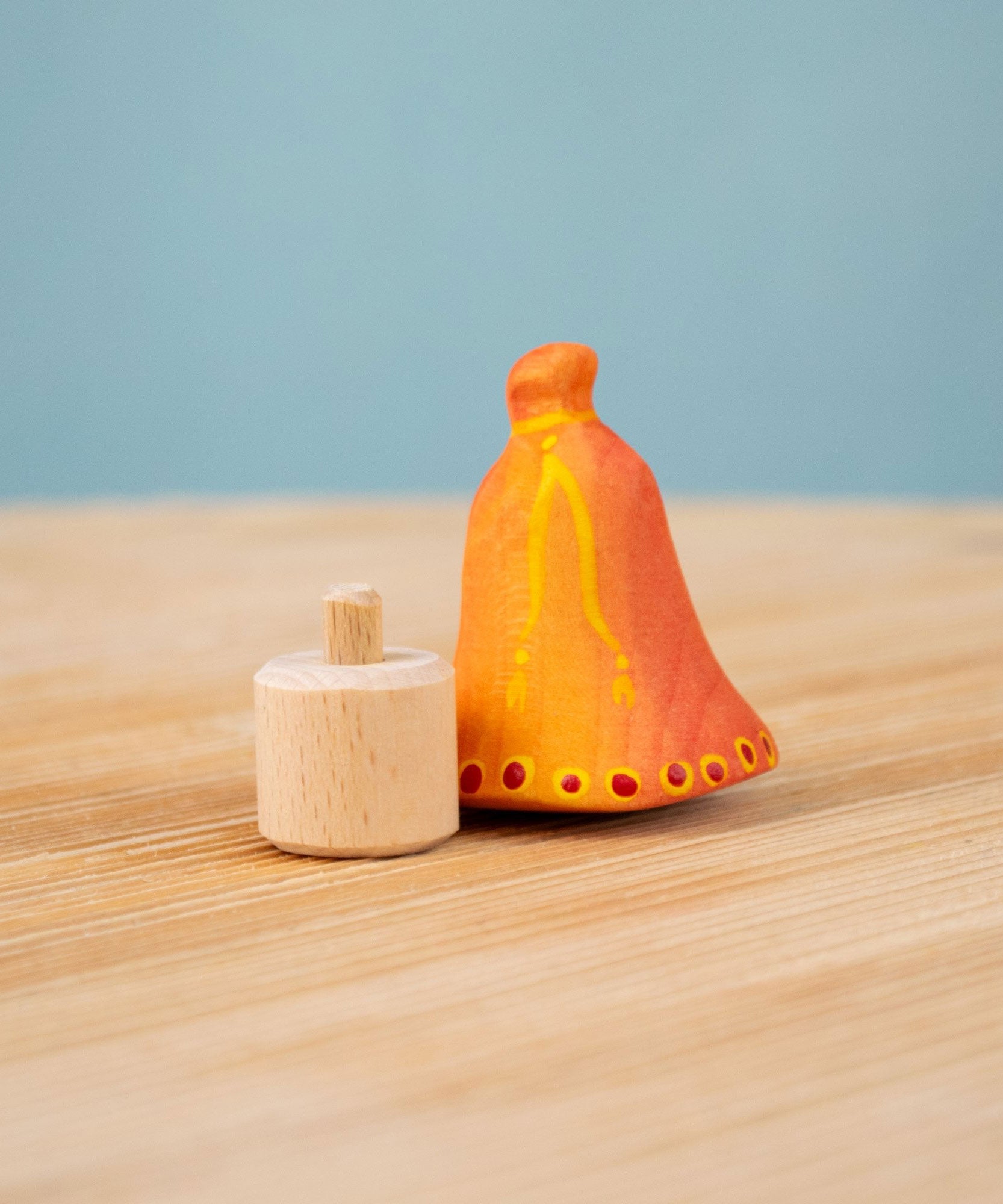 Bumbu Festive Bell Celebration decorative Figure to fit on a Grimm's celebration ring. The figure is shown with the bell seperate from the base. These festive figures are perfect for your Christmas celebration ring set up. These expertly hand crafted items are part of a large range of wooden toys available here at Babipur. 