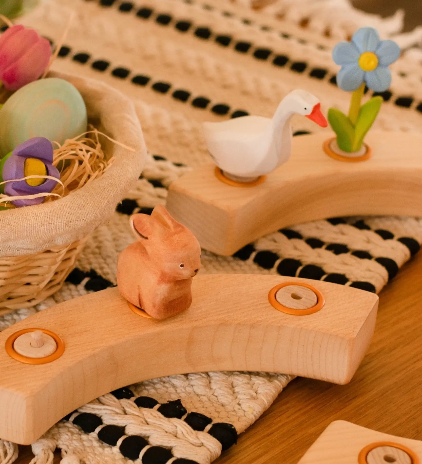 A Spring display showing the Bumbu white goose and brown rabbit decorative figures, celebration ring on a table mat