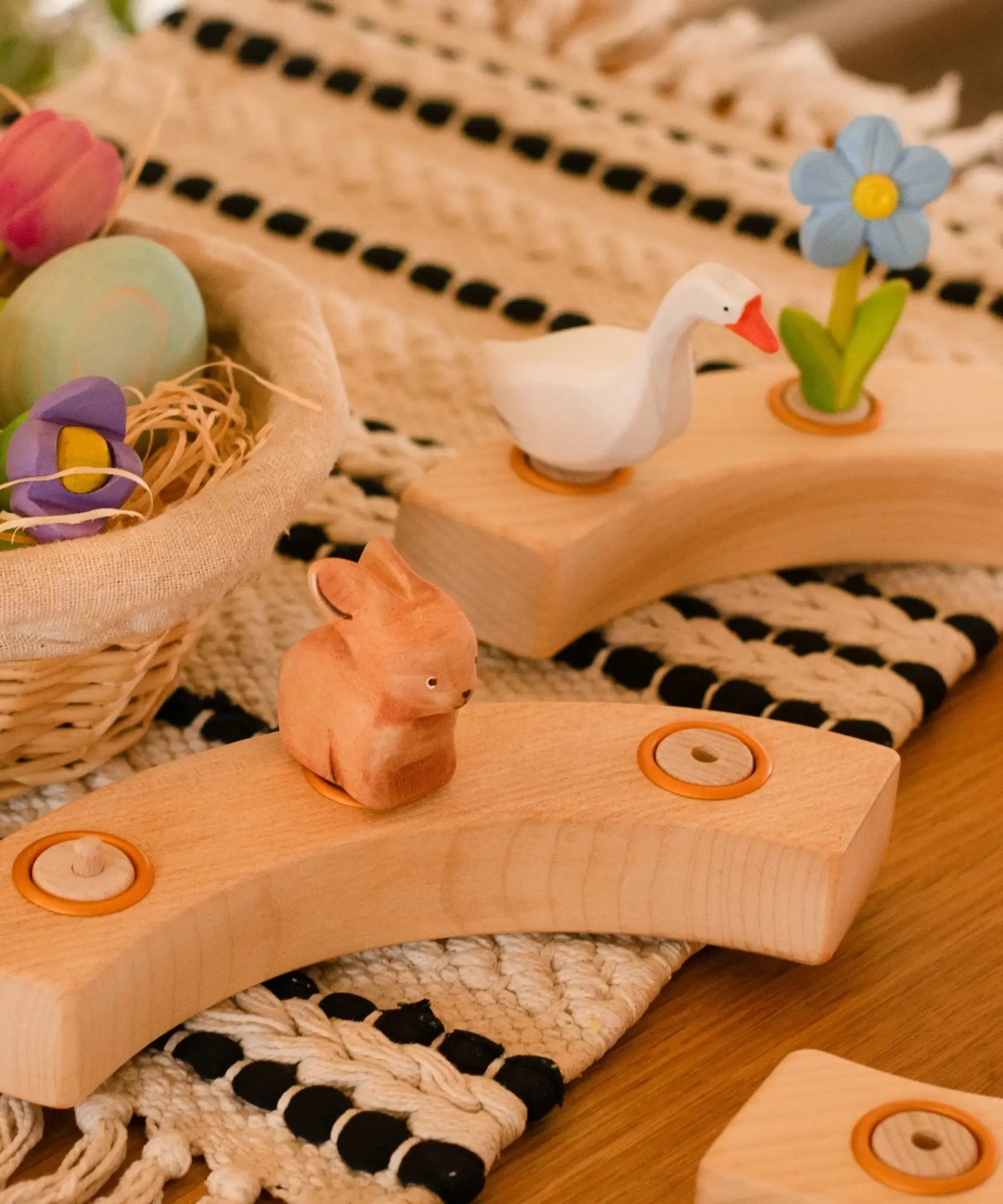 A Spring display showing the Bumbu white goose and brown rabbit decorative figures, celebration ring on a table mat