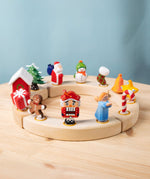 A collection of Bumbu Festive Celebration ring decorative Figures shown on a wooden ring. These festive figures are perfect for your Christmas celebration ring set up. These expertly hand crafted items are part of a large range of wooden toys available here at Babipur. 