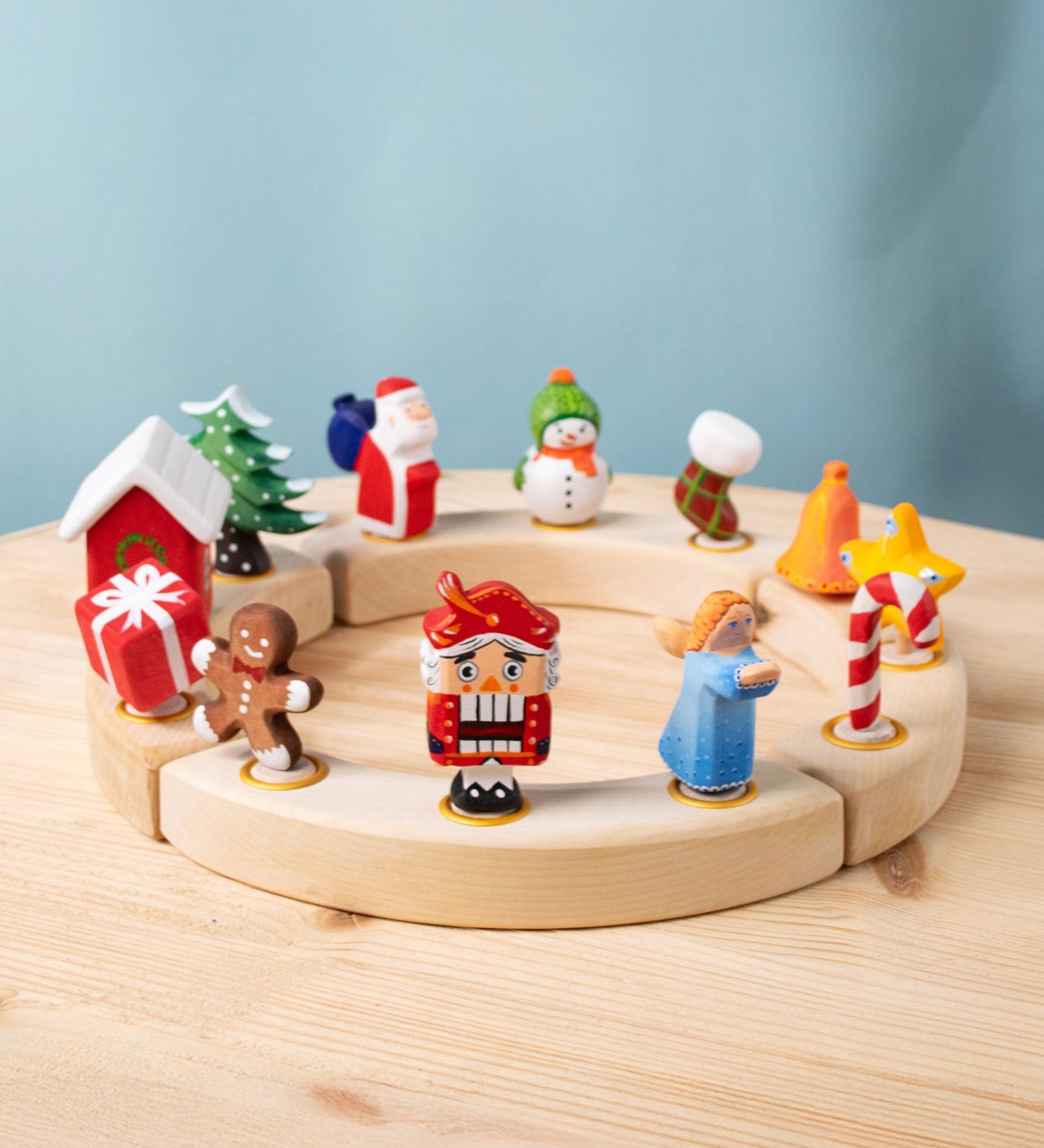 A collection of Bumbu Festive Celebration ring decorative Figures shown on a wooden ring. These festive figures are perfect for your Christmas celebration ring set up. These expertly hand crafted items are part of a large range of wooden toys available here at Babipur. 