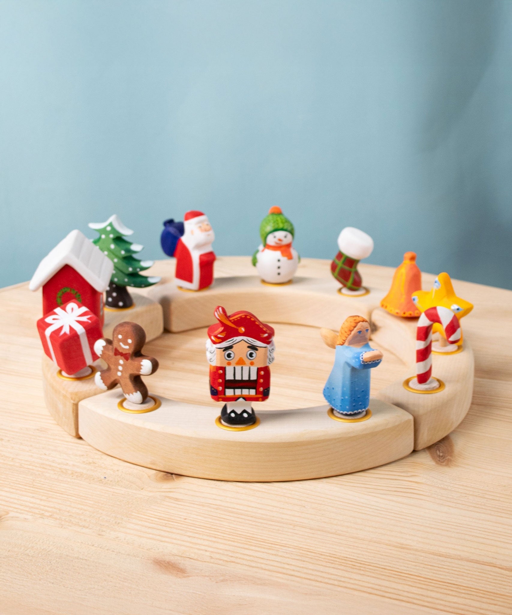 A collection of Bumbu Festive Celebration ring decorative Figures shown on a wooden ring. These festive figures are perfect for your Christmas celebration ring set up. These expertly hand crafted items are part of a large range of wooden toys available here at Babipur. 