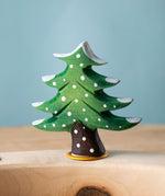 Bumbu Festive Tree Celebration decorative Figure to fit on a Grimm's celebration ring. The figure is a green fir tree decorated with snow.  These festive figures are perfect for your Christmas celebration ring set up. These expertly hand crafted items are part of a large range of wooden toys available here at Babipur. 