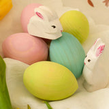 Bumbu handcrafted wooden easter eggs in yellow, green, blue and pink with white rabbits on top.