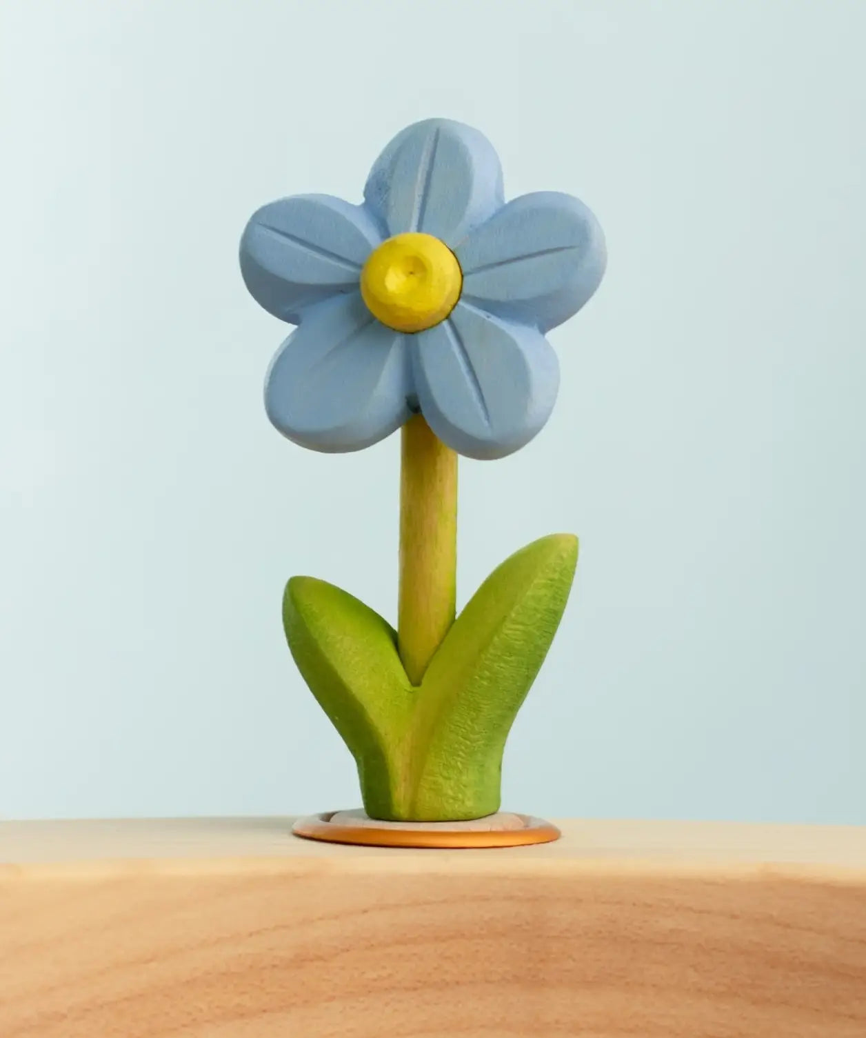 Bumbu wooden hand painted blue festive forget me not decorative figure standing in a celebration ring against a blue background