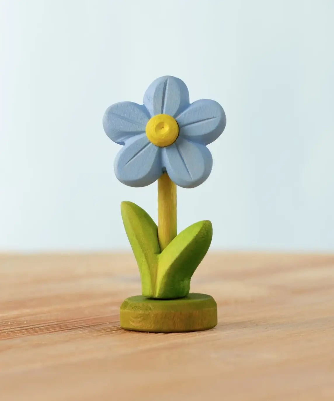 Bumbu handcrafted wooden blue festive forget me not figure standing on wooden green base 