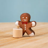 Bumbu Festive Gingerbread man Celebration decorative Figure to fit on a Grimm's celebration ring. The gingerbread man is shown separated from the little wooden base it comes with. These festive figures are perfect for your Christmas celebration ring set up. These expertly hand crafted items are part of a large range of wooden toys available here at Babipur. 