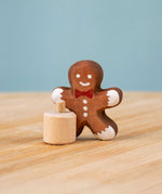 Bumbu Festive Gingerbread man Celebration decorative Figure to fit on a Grimm's celebration ring. The gingerbread man is shown separated from the little wooden base it comes with. These festive figures are perfect for your Christmas celebration ring set up. These expertly hand crafted items are part of a large range of wooden toys available here at Babipur. 