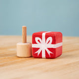 Bumbu red Festive Gift Celebration decorative Figure to fit on a Grimm's celebration ring. The figure is shown with the gift sepearated from the base These festive figures are perfect for your Chritmas celebration ring set up. Bumbu red Festive Gift Celebration decorative Figure to fit on a Grimm's celebration ring. These festive figures are perfect for your Christmas celebration ring set up. These expertly hand crafted items are part of a large range of wooden toys available here at Babipur. 