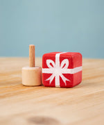 Bumbu red Festive Gift Celebration decorative Figure to fit on a Grimm's celebration ring. The figure is shown with the gift sepearated from the base These festive figures are perfect for your Chritmas celebration ring set up. Bumbu red Festive Gift Celebration decorative Figure to fit on a Grimm's celebration ring. These festive figures are perfect for your Christmas celebration ring set up. These expertly hand crafted items are part of a large range of wooden toys available here at Babipur. 